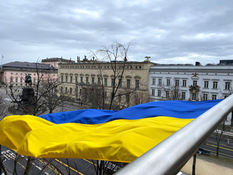 Ukraine Eine Flagge in Gelb und Blau weht über einer Straße