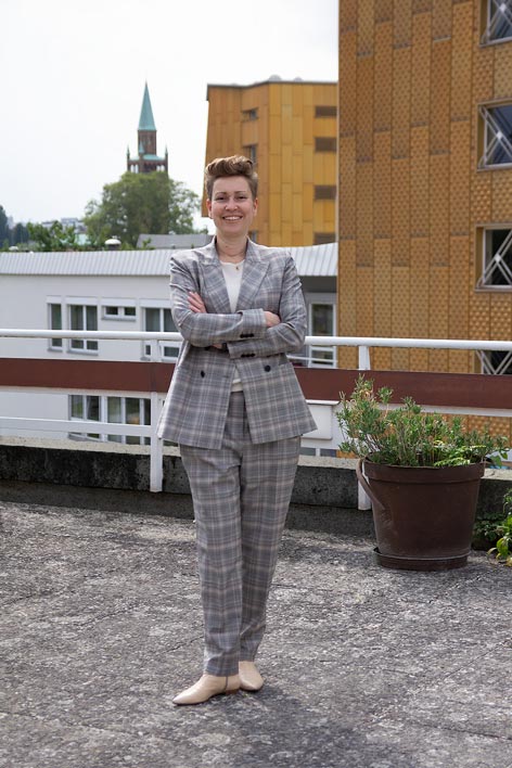 A woman in a suit poses for a picture
