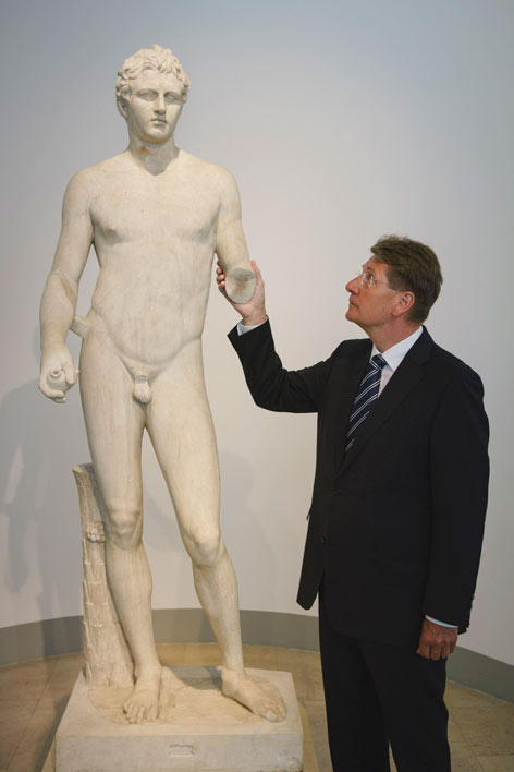 Axel Ekkernkamp untersucht eine römische Marmorstatue 