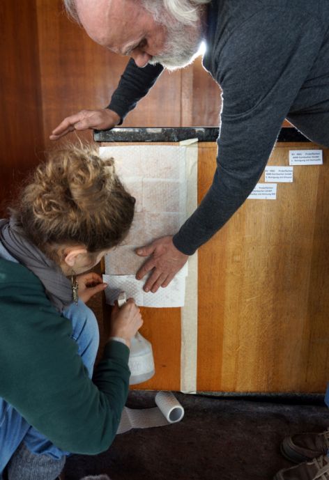 Der Holzrestaurator Wolfgang Dammbacher bringt Testanstriche auf dem Tresen für die Bemusterung auf.