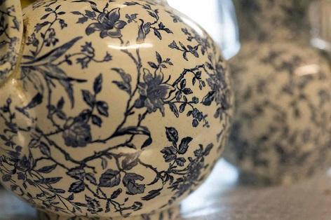Bauchiger Krug auf schmalem Standring, runde Schultern, konischer Hals mit ausladendem Rand, angesetzter Ohrenhenkel, auf der Wandung gedrucktes florales Dekor Vase mit Blumenmuster