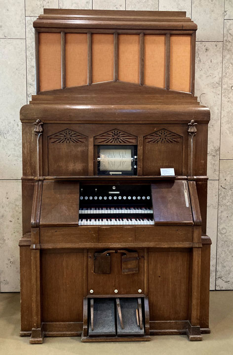 Large organ-like keyboard instrument made of wood.