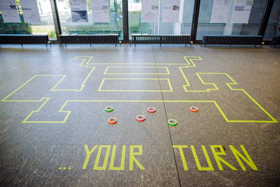 Aktionstag Dahlem Auf Steinboden sind mit Klebeband die Worte "Your Turn" geklebt