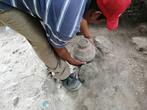 Ein Mann gräbt ein Keramikgefäß aus