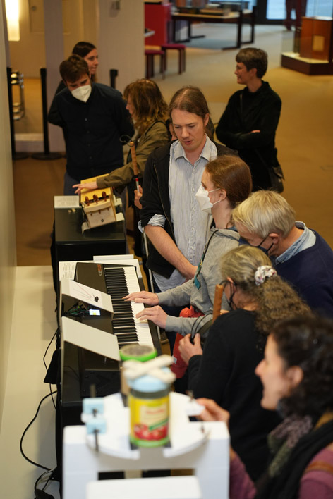 People are looking at objects in an exhibition of musical instruments