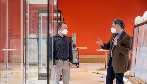 Jonathan Fine im Humboldt Forum Zwei Männer unterhalten sich in einem leeren Ausstellungsraum