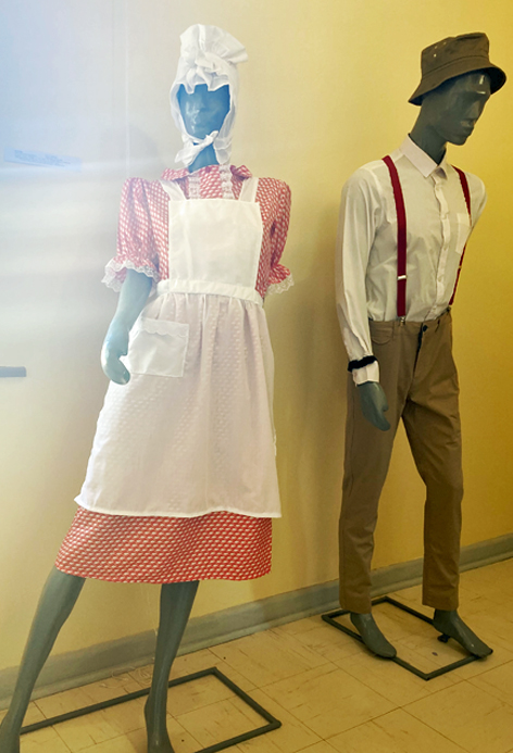 Ausstellungsstücke im Museum of Namibian Fashion in Otjiwarongo Schaufensterpuppen, jeweils bekleidet mit knielangem Kleid und Schürze, bzw. Hemd, Hose und Hosenträgern