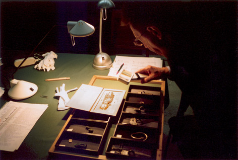 Mensch untersucht archäologische Objekte am Schreibtisch