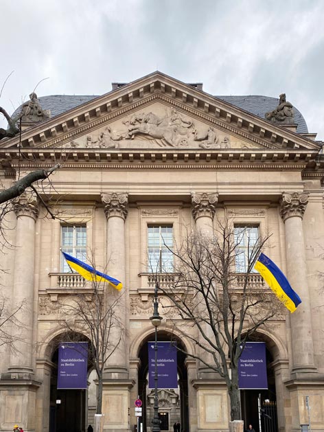 Staatsbibliothek Gebäudefassade mit Flaggen in Blau und Gelb