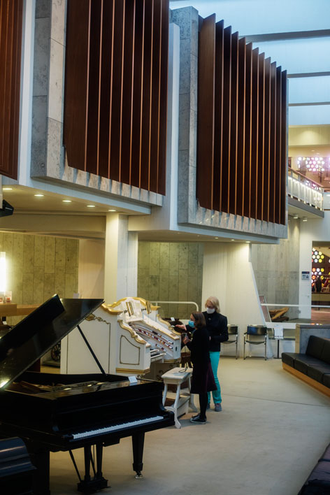 An exhibition room with a large organ and a grand piano.