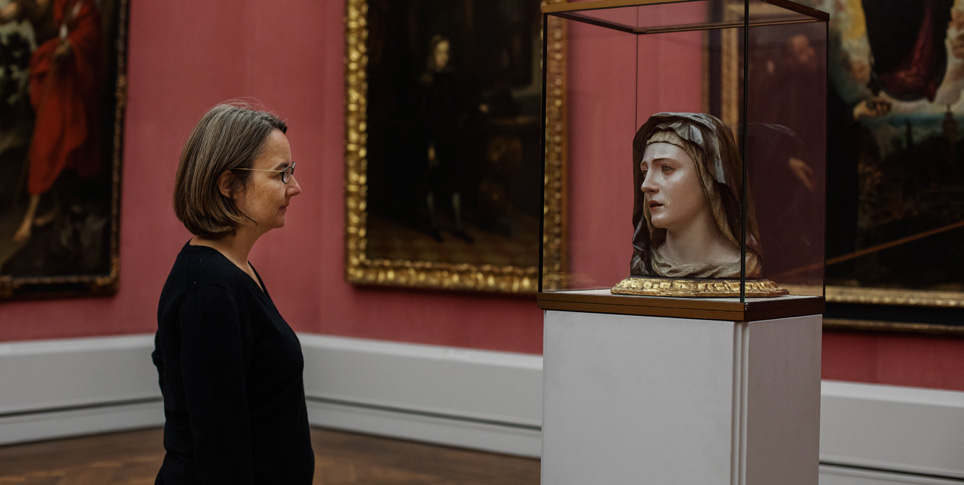 Elke Buhr Eine Frau sieht sich ein Ausstellungsstück im Museum an.