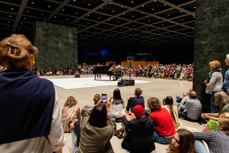 Jazzlegende Till Brönner spielt zum krönenden Abschluss in der Mies-Halle © Stefanie Heider Menschen lauschen einem Trompeter und einem Flügel in einer großen Halle