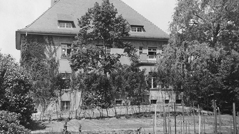 Black and white photo of a villa with a garden