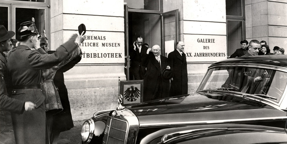 Bundespräsident Heuss beim Verlassen der kurz zuvor eröffneten Galerie des 20. Jahrhunderts in der Jebensstraße. Rechts neben ihm Otto Suhr, Regierender Bürgermeister von Berlin, hinter den beiden Galeriedirektor Jannasch (29. Januar 1955)