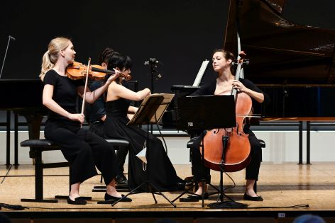 Die drei Musikerinnen von Trio Hannari sind auf einer Bühne und spielen Kammermusik