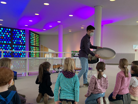 Familienführung "Voller Klang voraus!" Ein Mann zeigt Kindern ein Instrument
