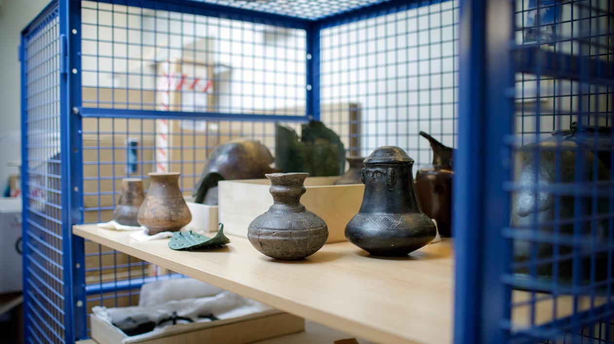 Ceramic objects in an open lattice cabinet in the depot