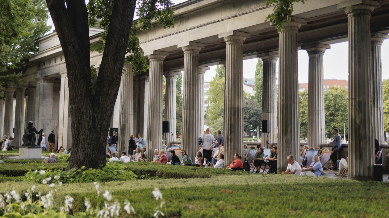Fotografie der Kolonnaden auf der Museumsinsel mit sitzenden und stehenden Menschen