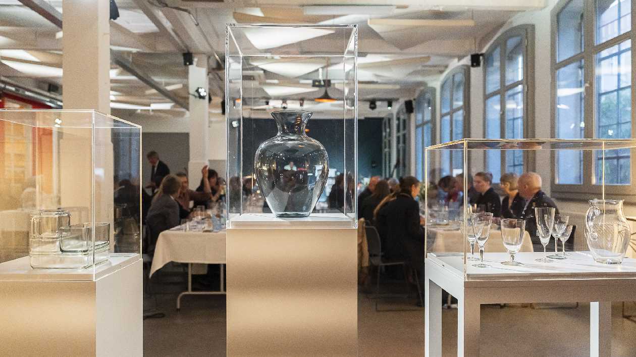 Glasvitrinen mit Dinnergästen im Hintergrund