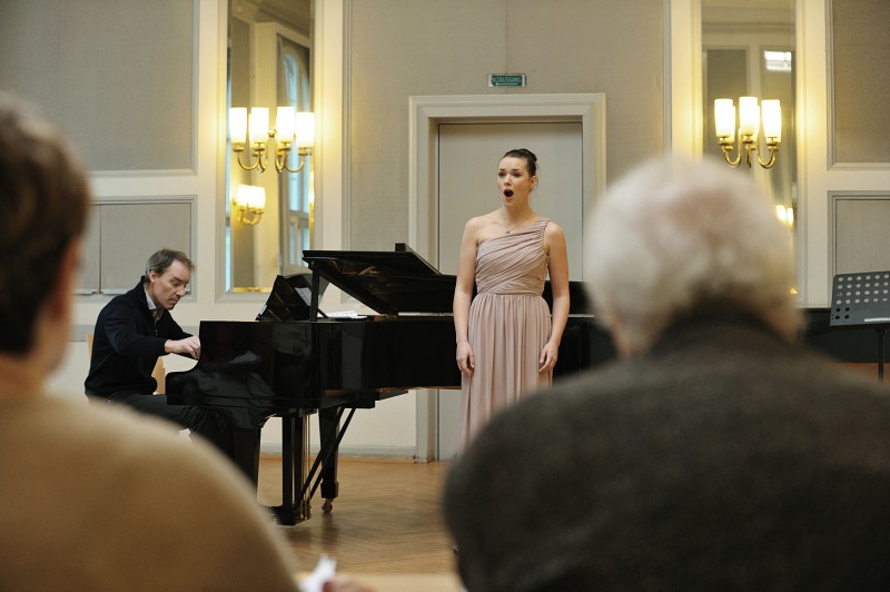 Eine singende Frau steht vor einem Klavier, das ein Mann spielt. Im Vordergrund ist das Publikum zu sehen (öffnet Vergrößerung des Bildes)