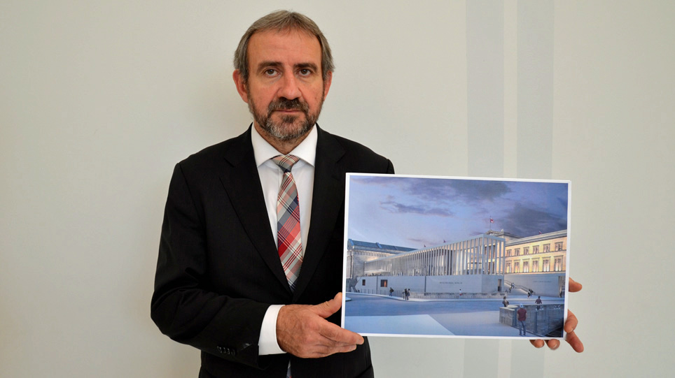Ein bärtiger hält eine Farbfotografie hoch 