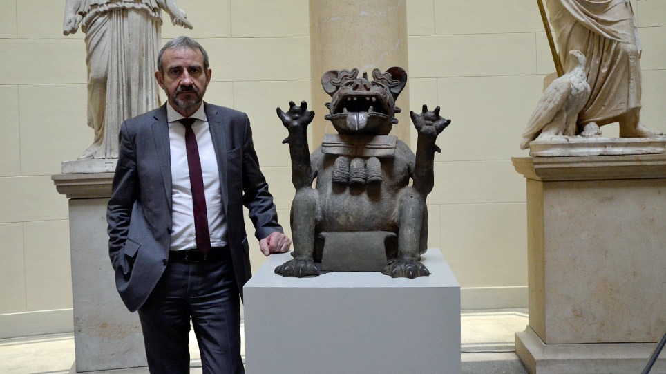 Ein Mann steht in einem Museum neben einer Skulptur