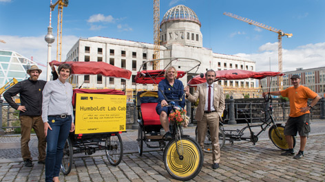 Hermann Parzinger und die Piloten der „Lab Cab“-Fahrradrikschas vor dem Berliner Schloss