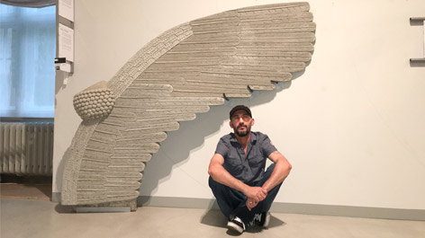 Mohammed Alkhatib vor einem Flügel aus Beton, den er als Teil der Ausstellung „daHeim – Einsichten in flüchtige Leben“ geschaffen hat