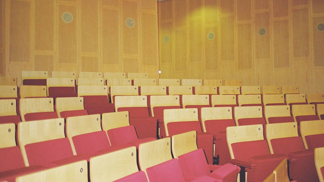 Curt-Sachs-Saal Ein mit Holz verkleideter Konzertsaal mit rot gepolsterten Sitzen