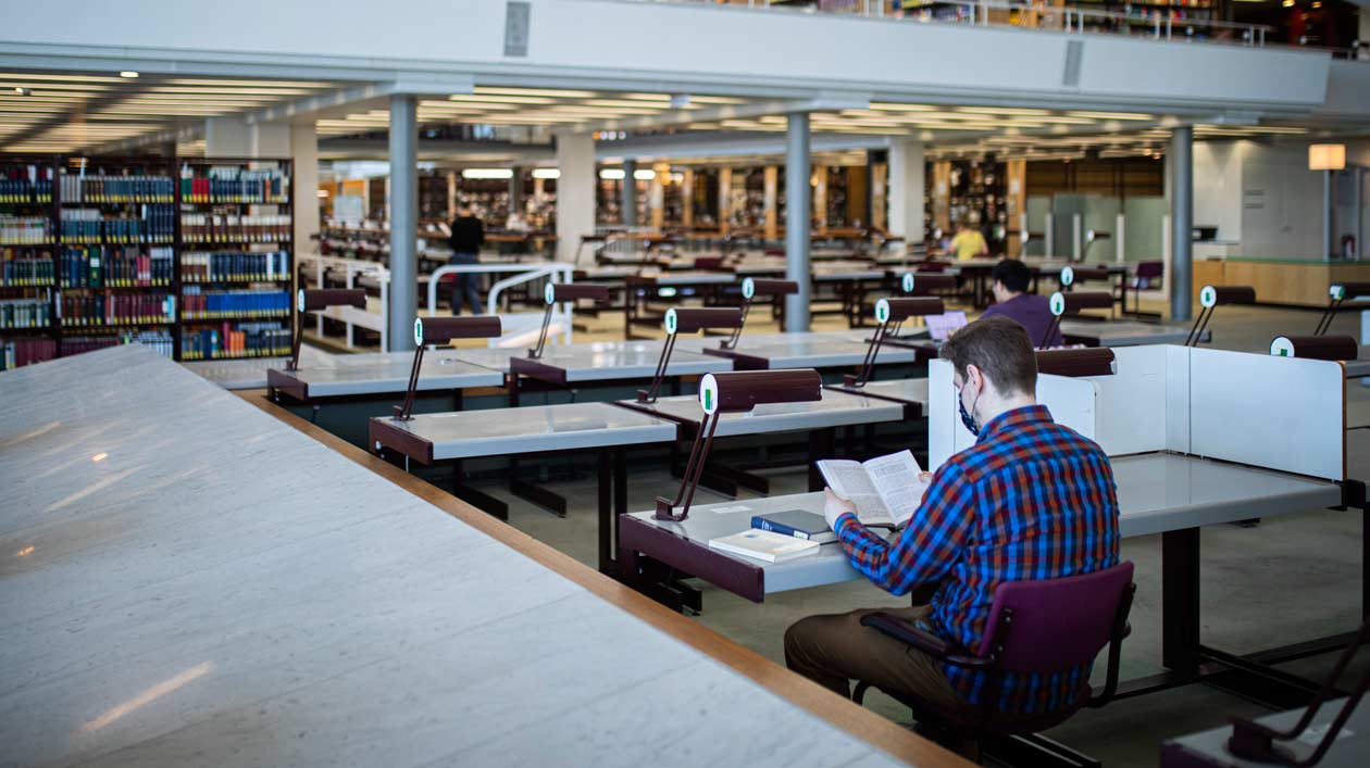 Ein Mann sitzt in einer modernen Bibliothek