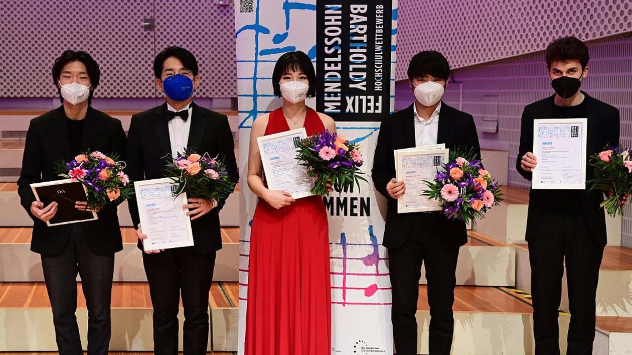 Five people holding up certificates