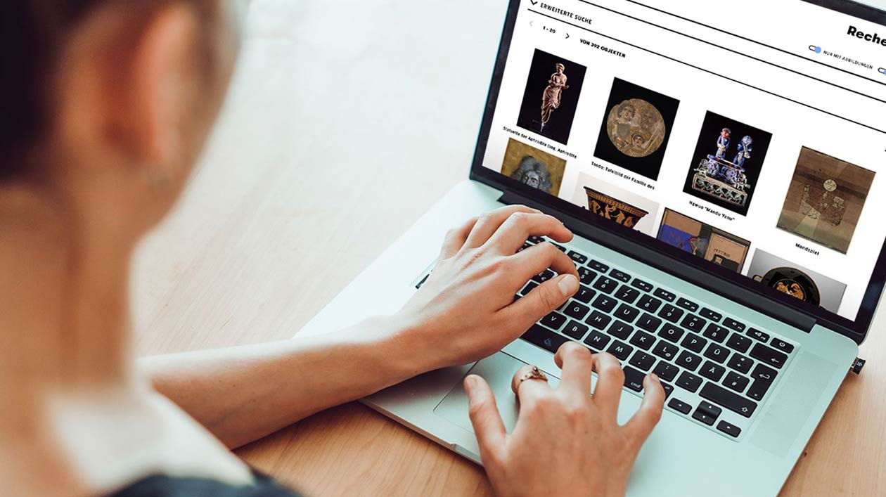 A person looking at a notebook with a database of museum objects