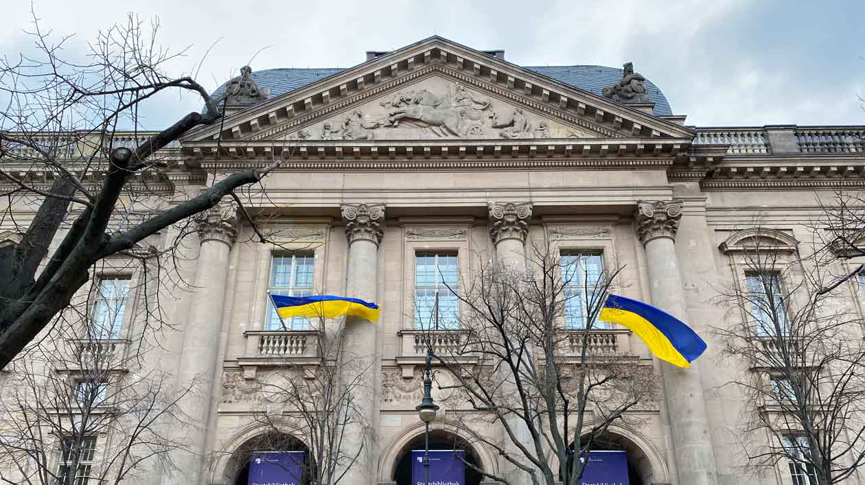 Façade of the State Library Unter den Linden with two Ukrainian flags