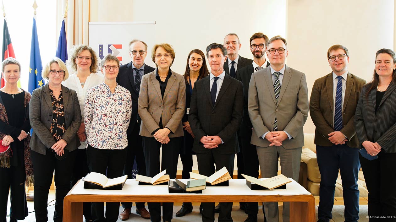 Gruppenfoto bei der Restitution von Büchern aus der Staatsbibliothek an Le Figaro in der französischen Botschaft