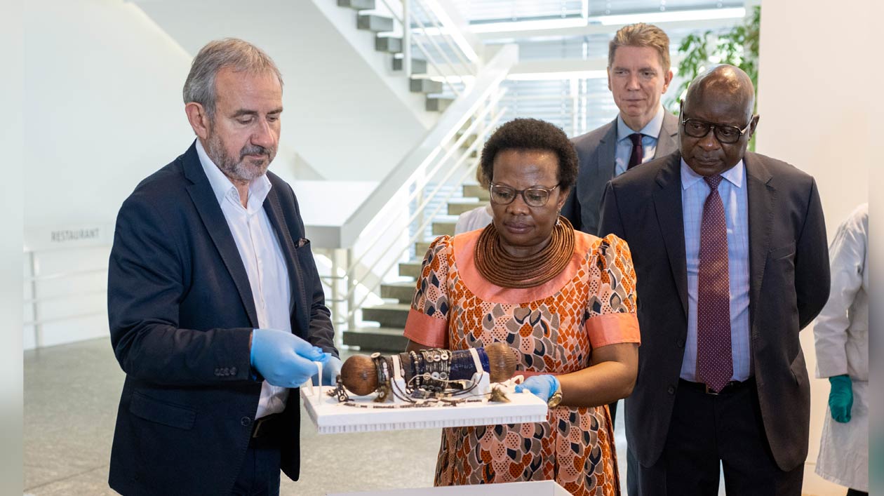 23 Objekte reisten nach Namibia 2 Personen mit blauen Gummihandschuhen packen ein Objekt in eine Transportbox ein, 2 Personen schauen von hinten zu