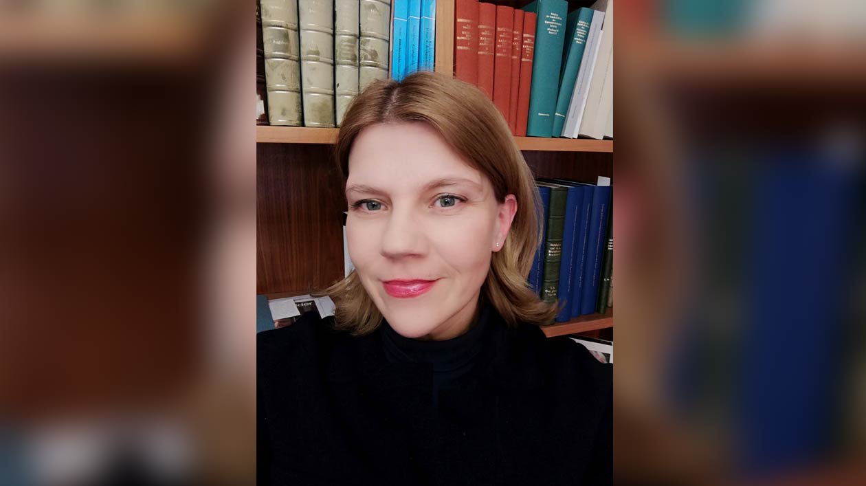 Portrait of a woman in front of a bookshelf