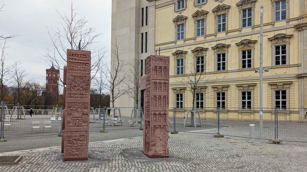 Rekonstruktion des Sanchi-Tors vor dem Humboldt Forum Zwei rote Sandsteinstelen vor einer barocken Fassade