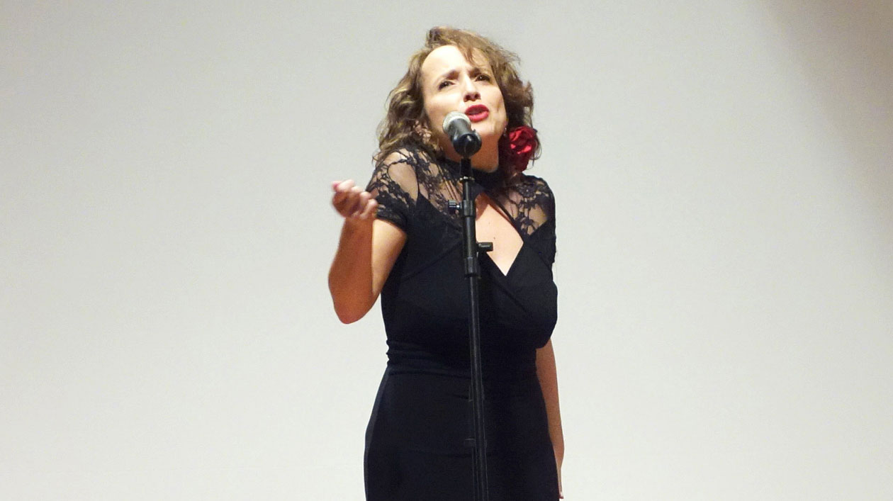 Eine Frau im schwarzen Kleid singt