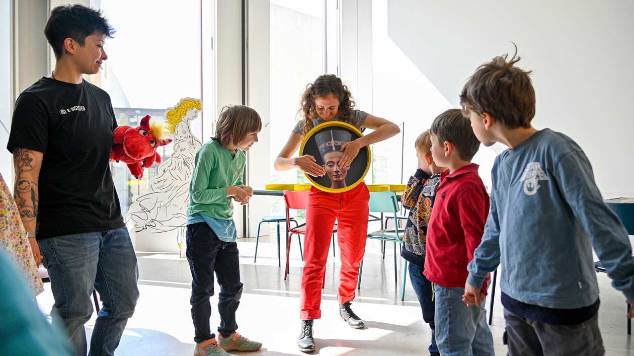 Eine Kunstvermittlerin interagiert mit einer Gruppe von Kindern