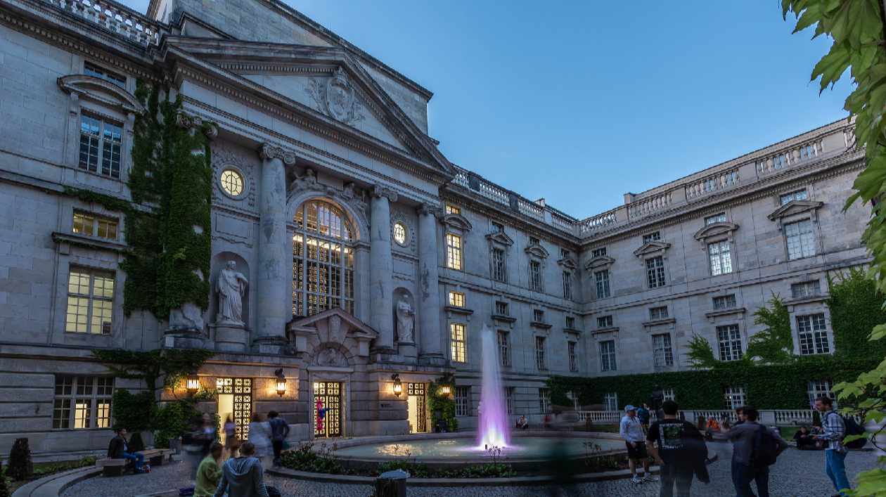 Staatsbibliothek anlässlich der Langen Nacht der Wissenschaften 2023 Bild eines großen Gebäudeinnenhofs mit Menschen bei Nacht