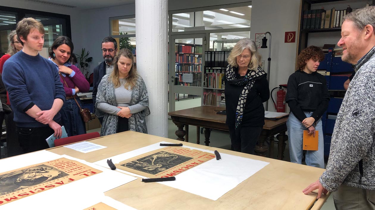 Jüdische Studien treffen Lateinamerikaforschung: Ein internationaler Workshop zu Utopie und Krise Personen stehen um einen Tisch in einer Bibliothek