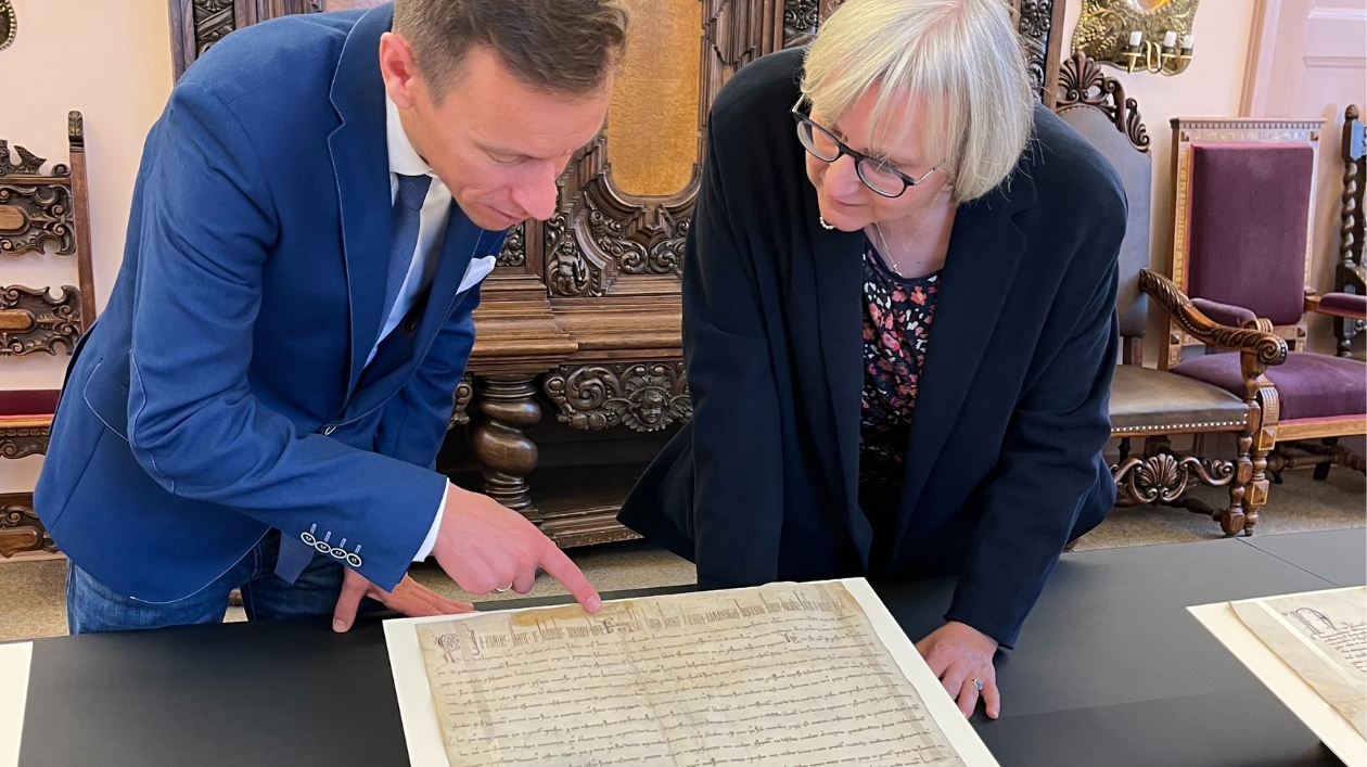 Zwei Personen begutachten eine Urkunde