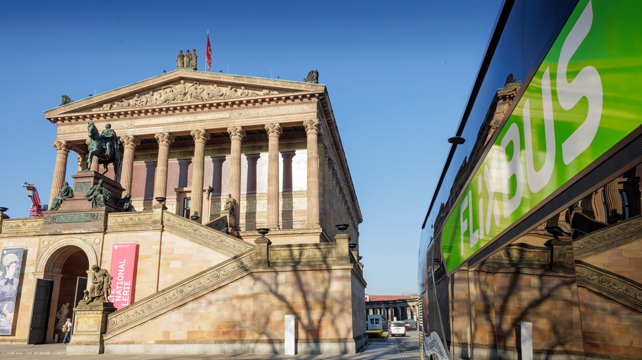 Ein grüner Bus parkt vor einem neoklassizistischen Museumsgebäude