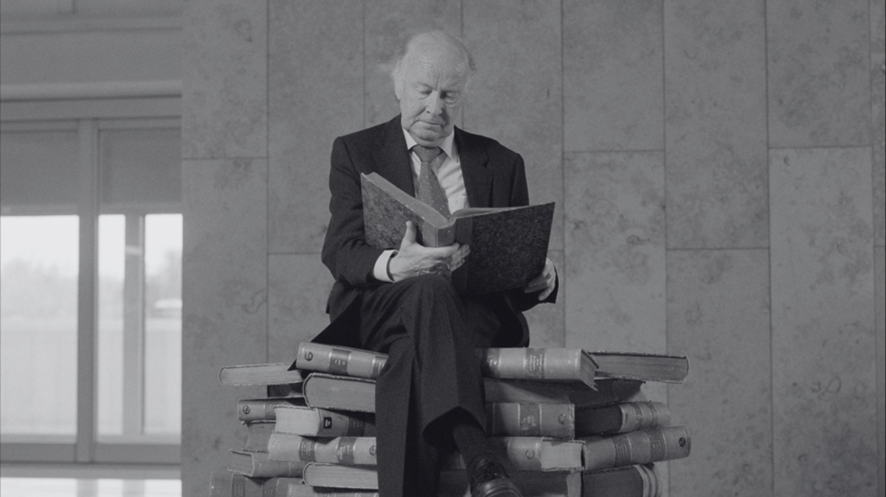 Saur ein Mann auf einem Stapel Bücher