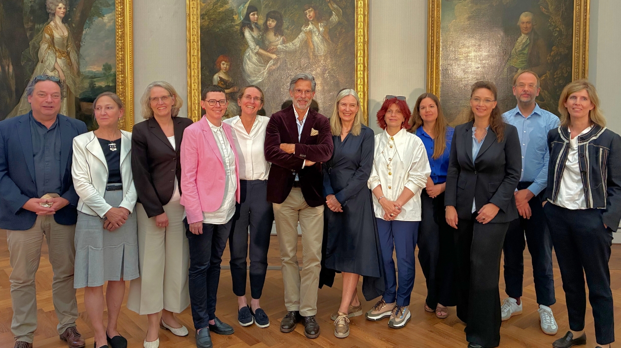 ein Gruppenfoto vor einem Gemälde