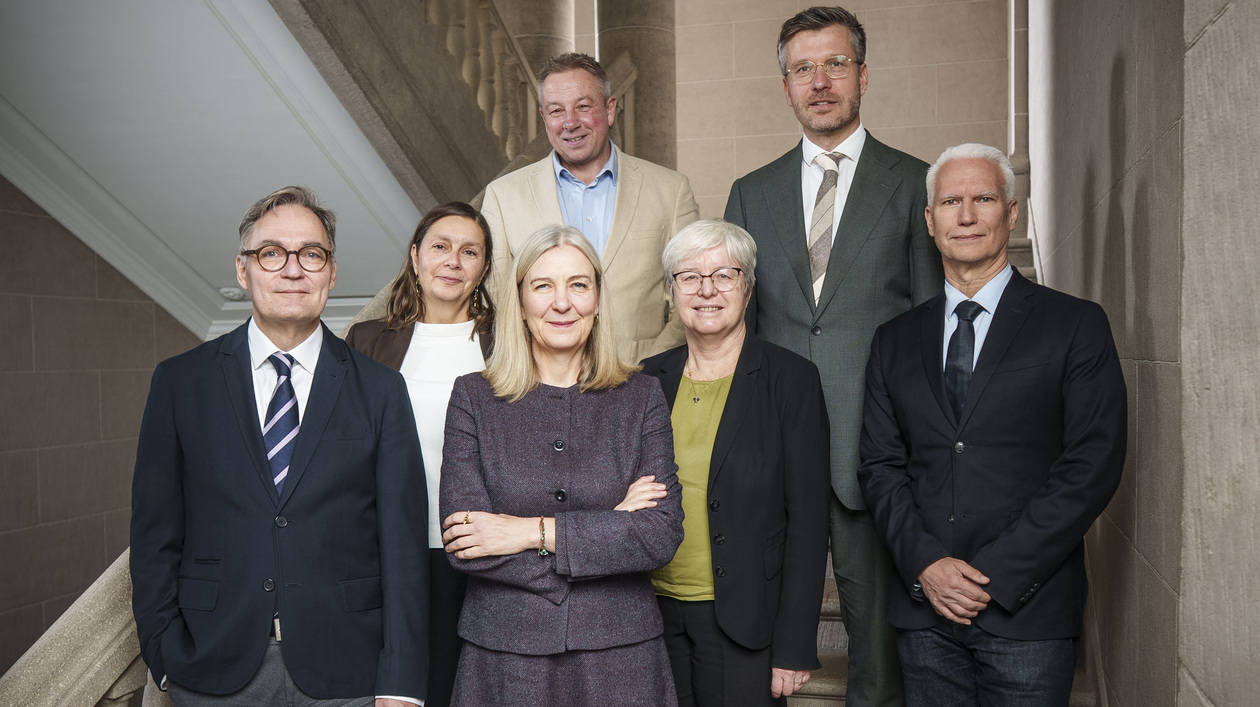 3 Frauen und 4 Männer auf einer Treppe