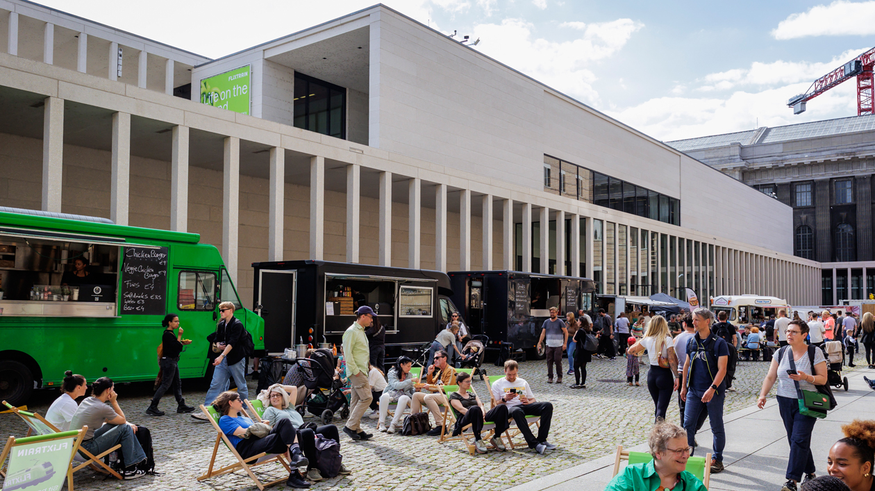 People and food trucks in the courtyard of the James Simon Gallery